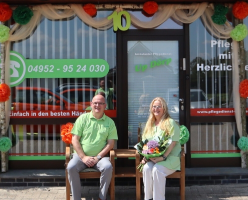 Jörg und Melanie Jelden sitzen unter dem Türkranz zum 10-jährigen Firmenjubiläum.
