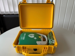 Mobiler Defibrillator in gelber Transportbox