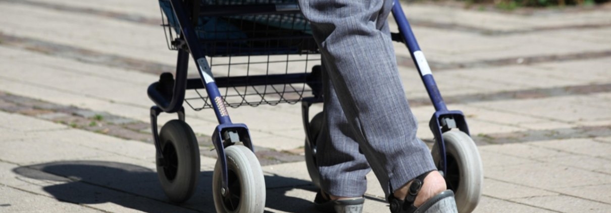 Die Beine einer Seniorin. Läuft am Rollator.