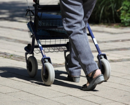 Die Beine einer Seniorin. Läuft am Rollator.